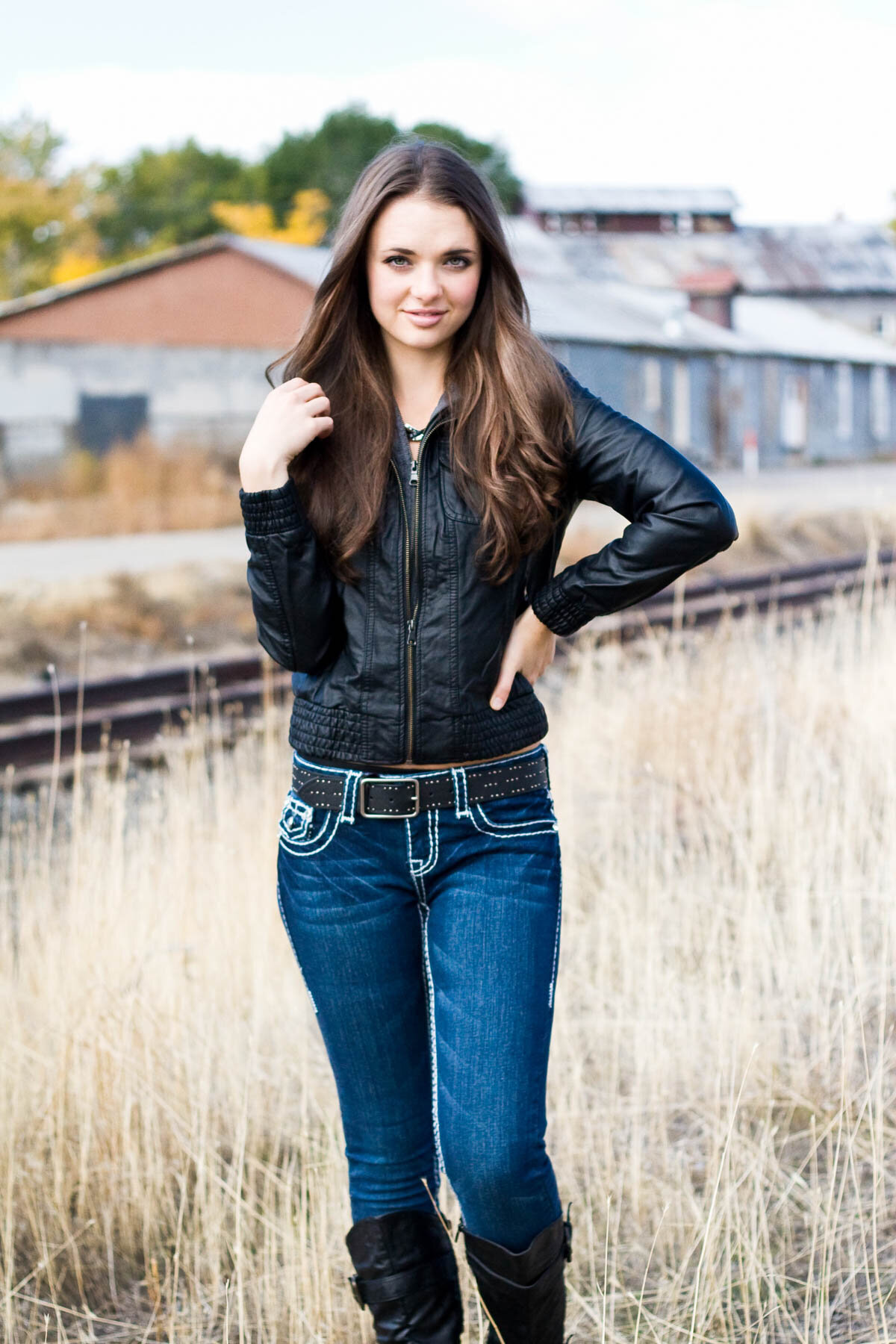 Senior girl posing near abandoned railway train tracks in Lehi, Utah.