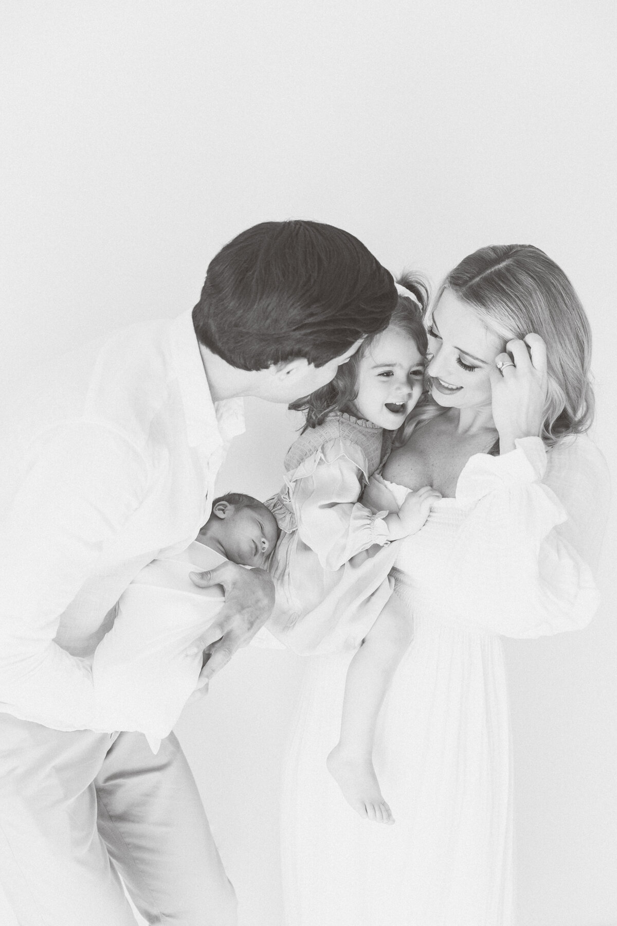 family cuddling their newborn in a bright Charlotte nursery — Charlotte newborn photographer