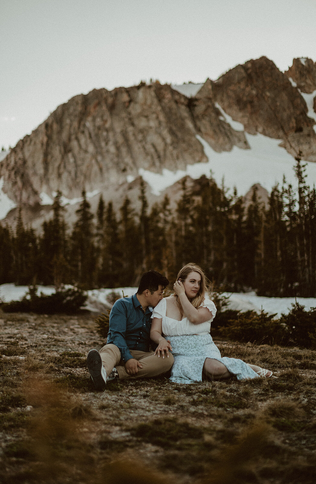 couple sits in grass at medicine bow wyoming 