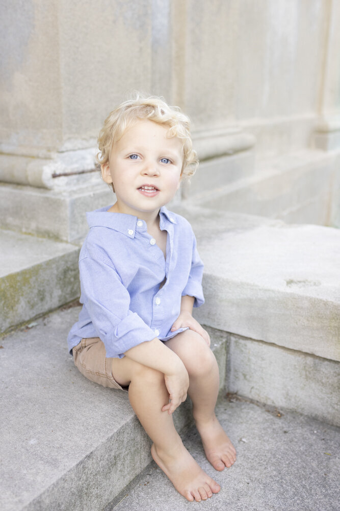 young boy poses on the steps
