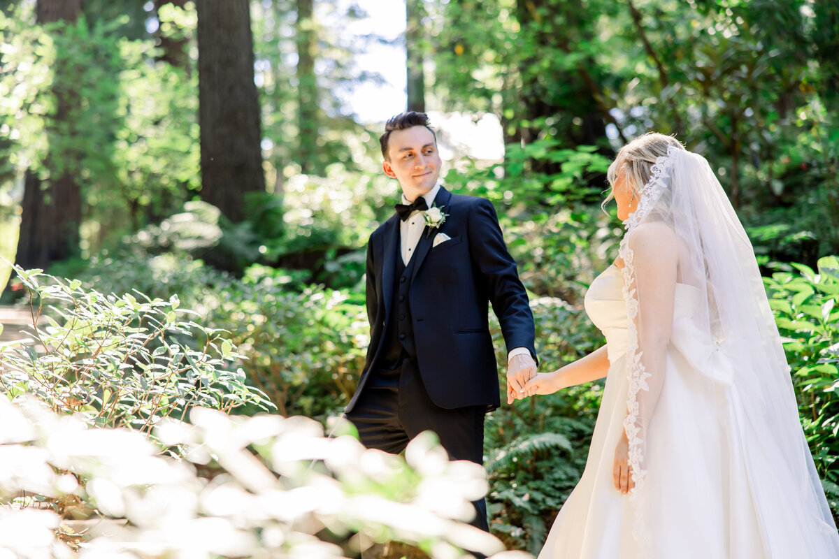 Bride and groom walk in ocean side garden at Whispering Rose Ranch at sunset