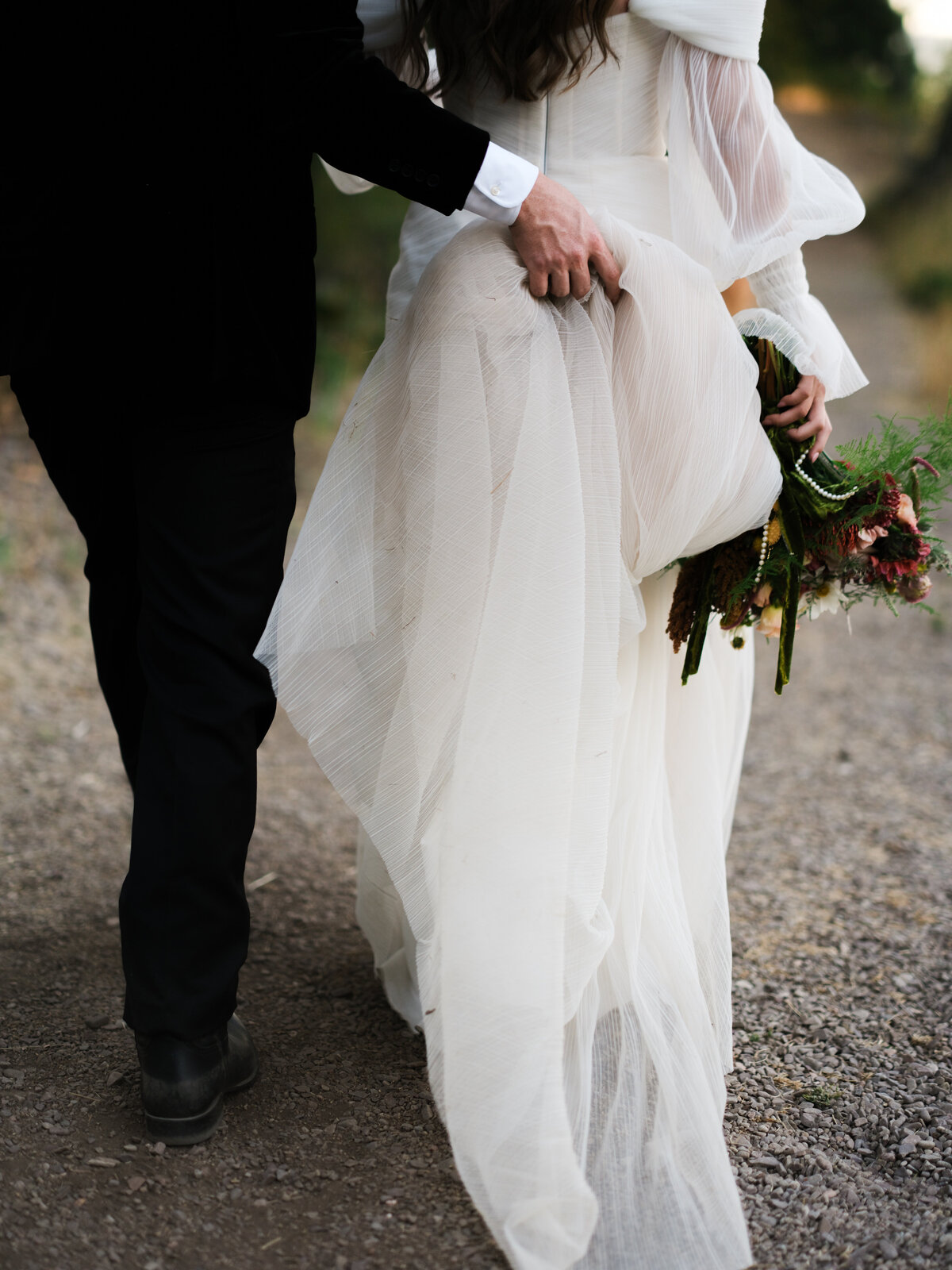 groom helping bride with dress
