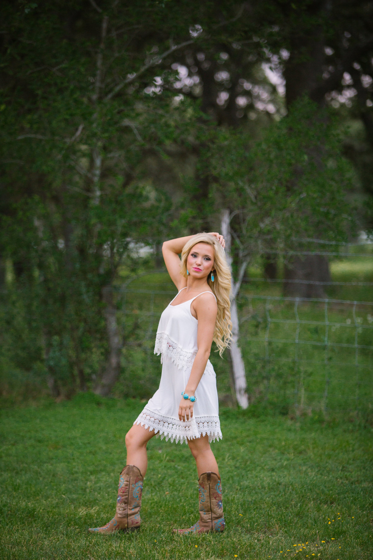 high school senior girl in white dress posing for San Antonio senior photographer