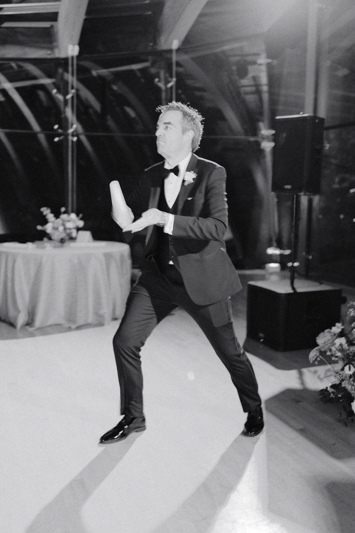 A black and white weddign day photo of a guests dancing during the reception at Crystal Bridges Museum of American Art