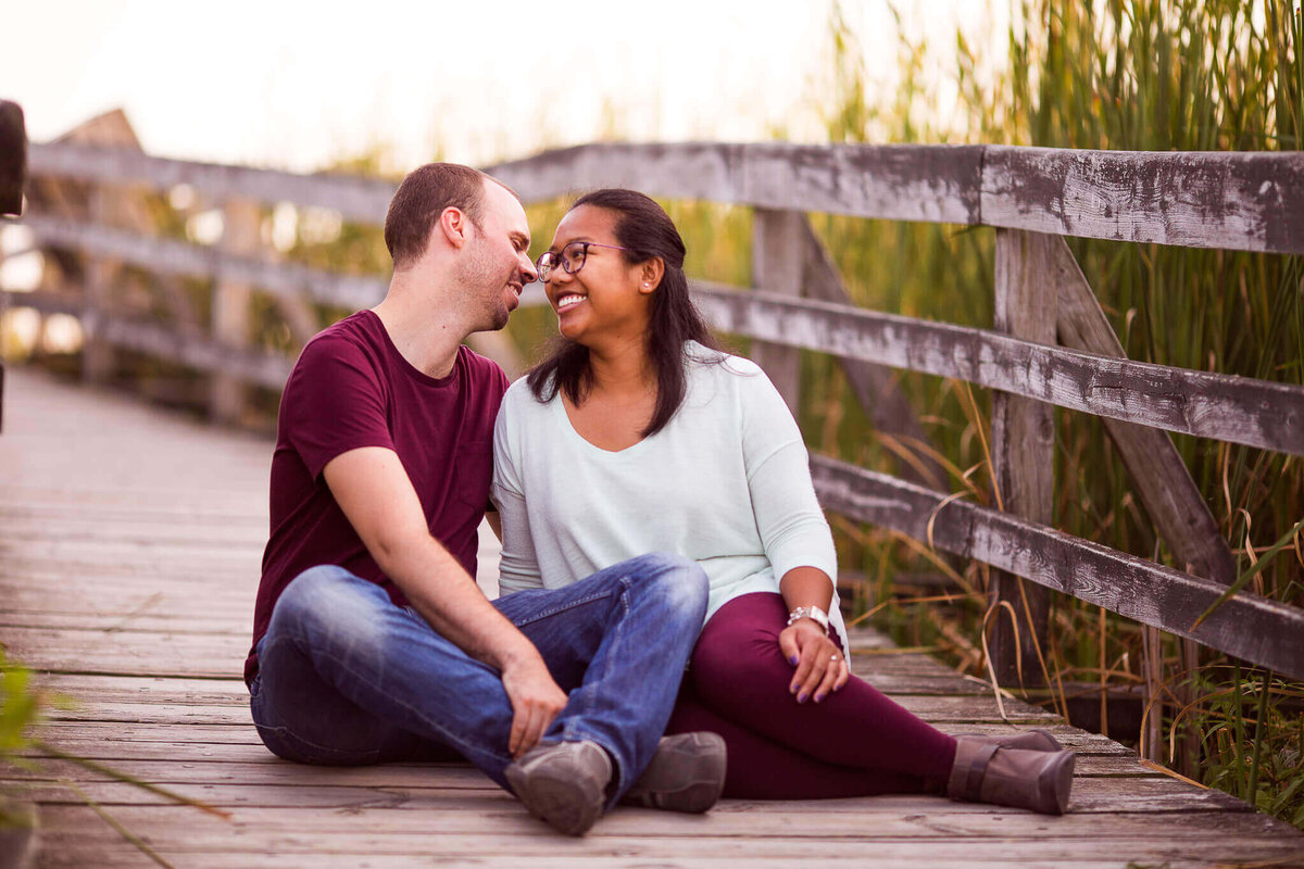 Couple embrace on boardwalk during Point Pelee engagement session