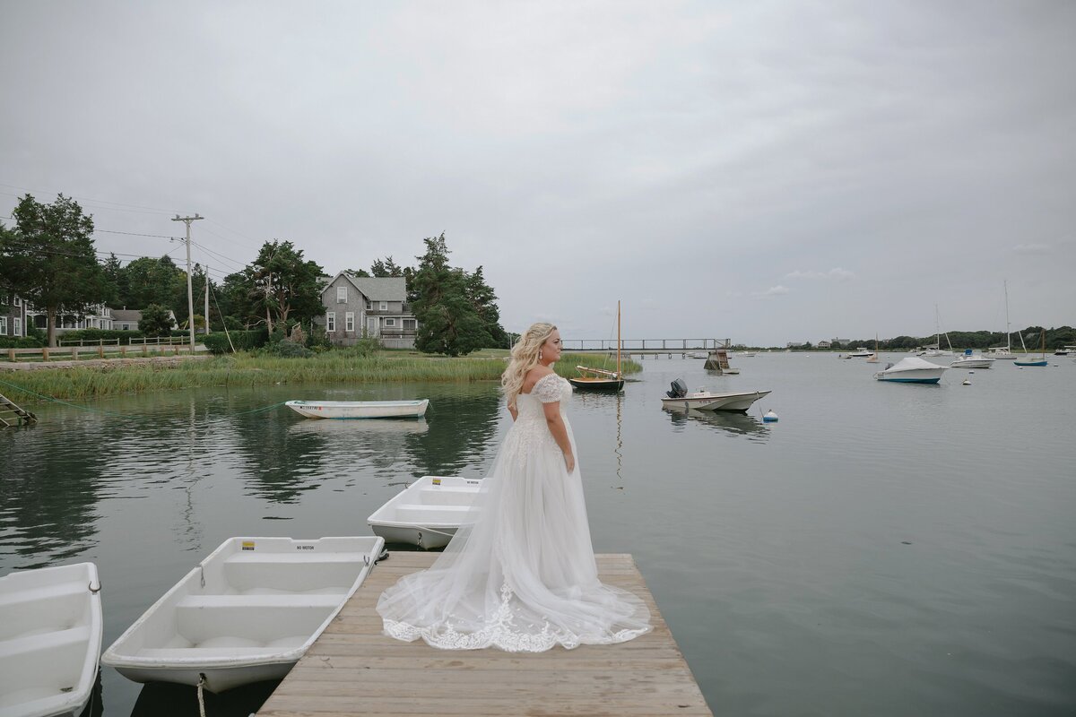 Bride poses on dock during Cape Cod wedding.