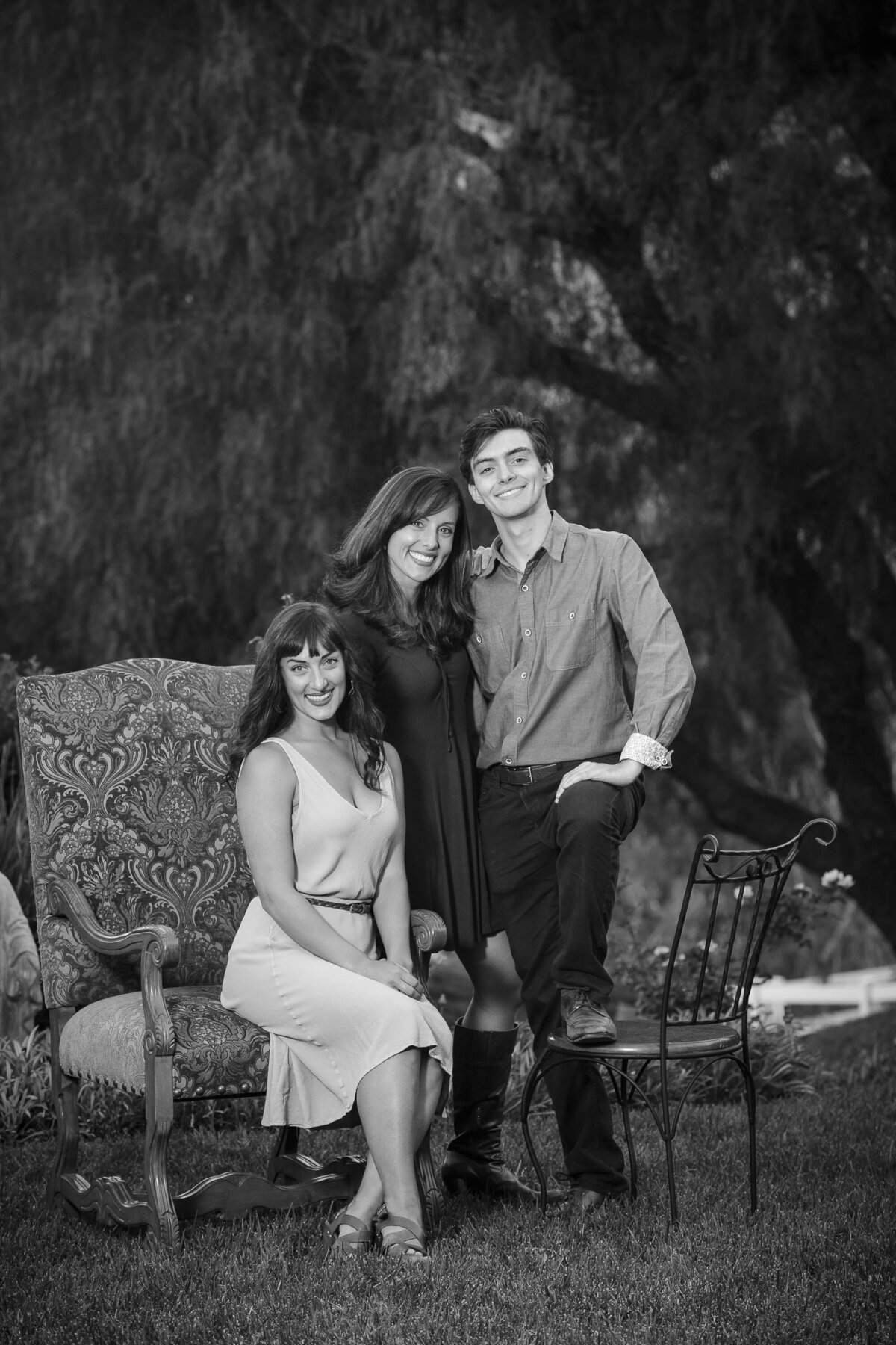 Black and white photo of three siblings smiling together