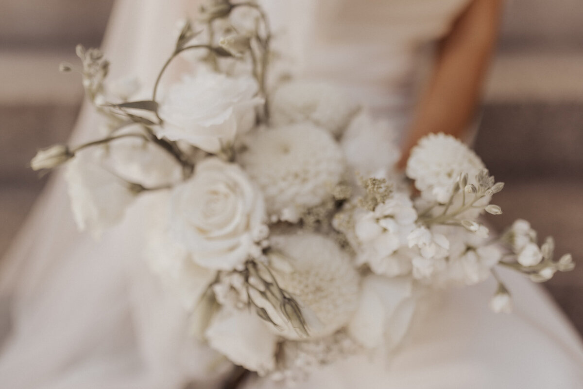 A close-up of a bridal bouquet with soft-focus white flowers.