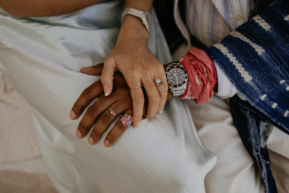interracial bride and grooms hands together with their rings and jewelry