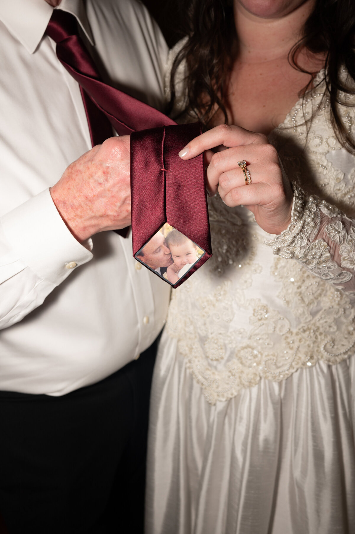 Two people holding up a tie showing off the inside of it