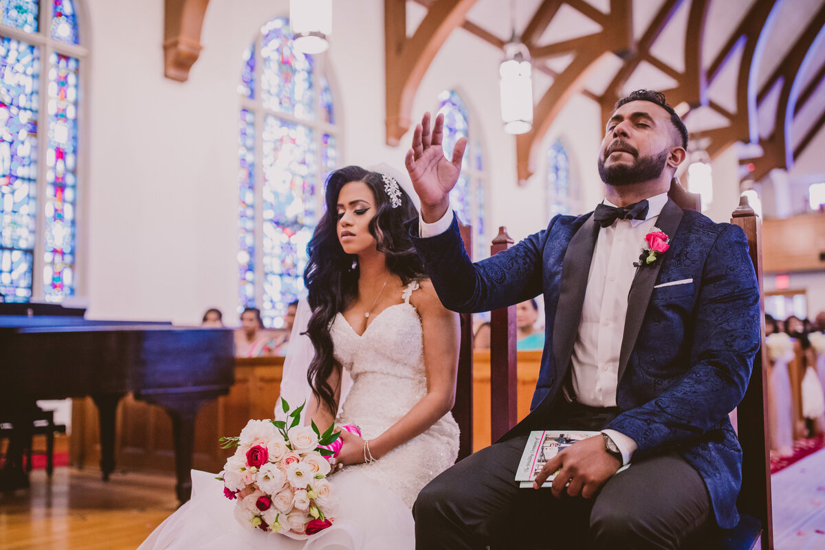 Indian christian groom shedding a tear during the prayer during the wedding ceremony at church