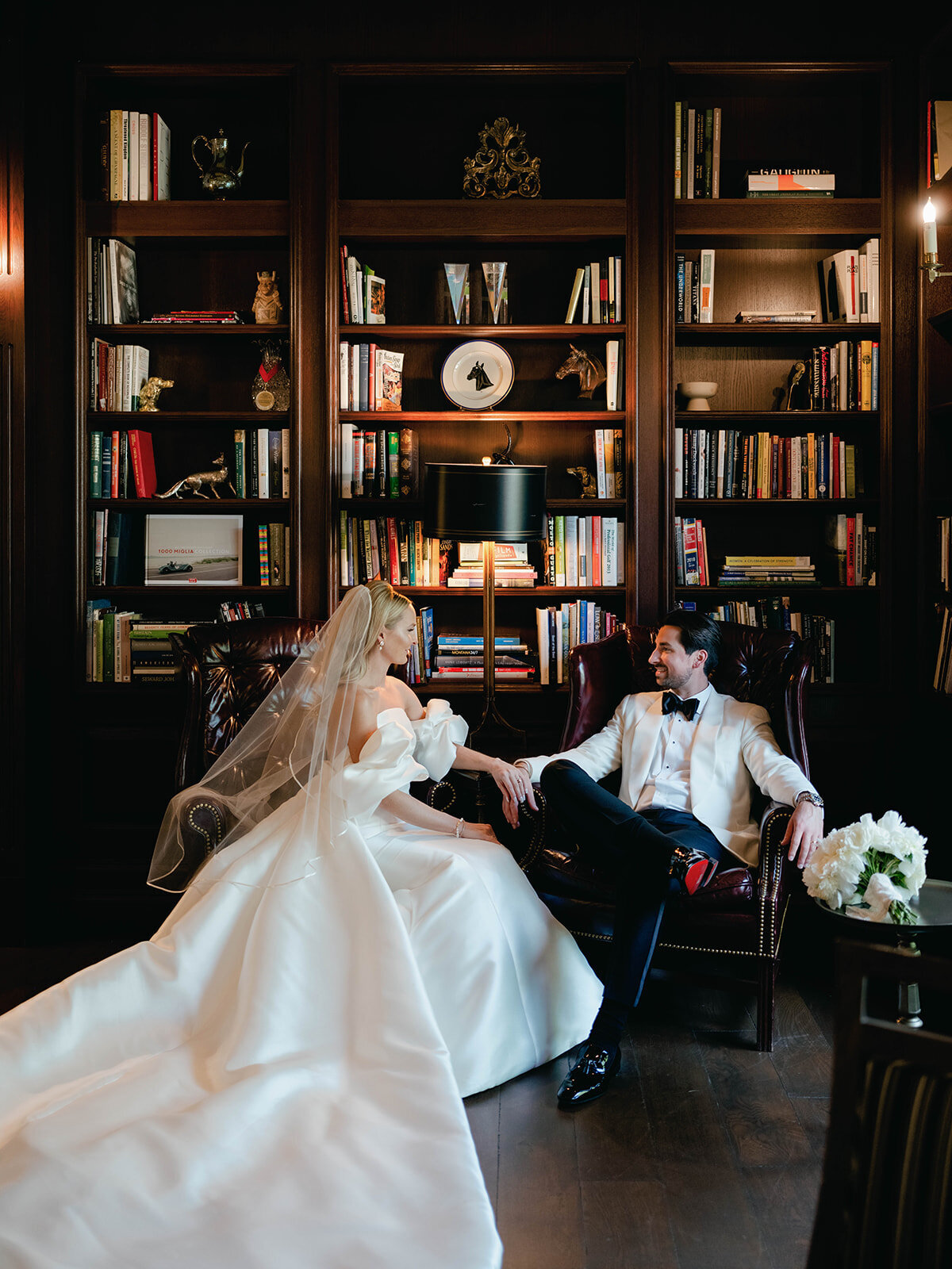 Bride and groom look at each other as they sit in the library at Salamander Resort