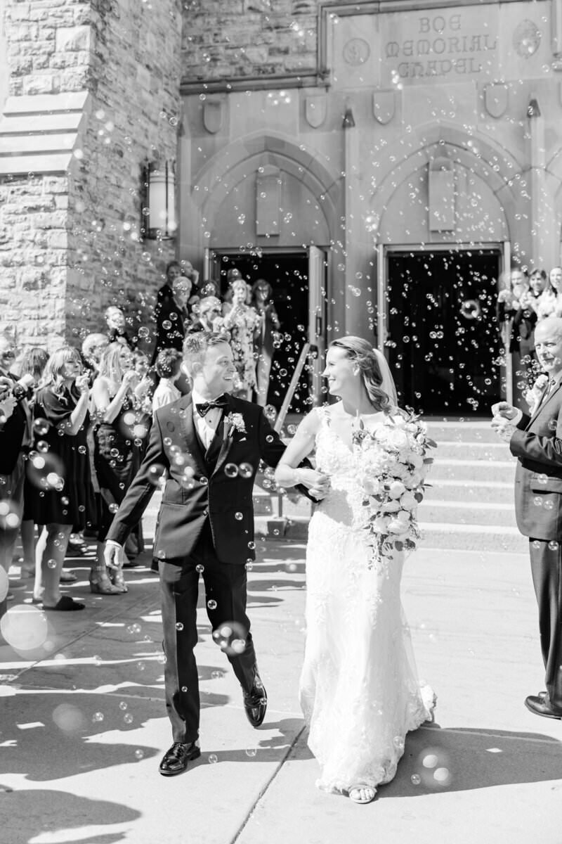 couple walking after married surrounded by bubbles by mpls wedding photographers