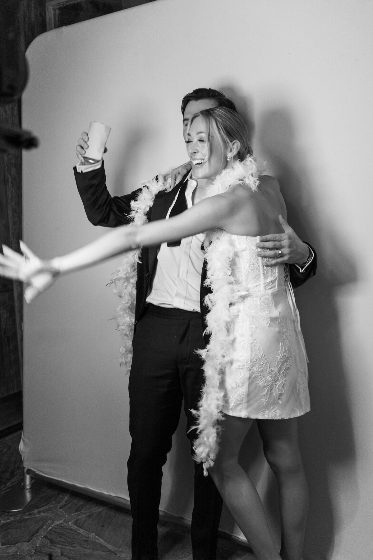 Black and white image of a bride and groom at their wedding photobooth