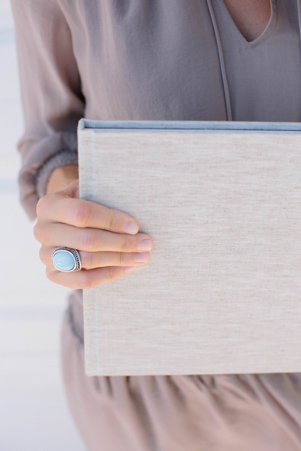 woman's hand holding a linen wedding album