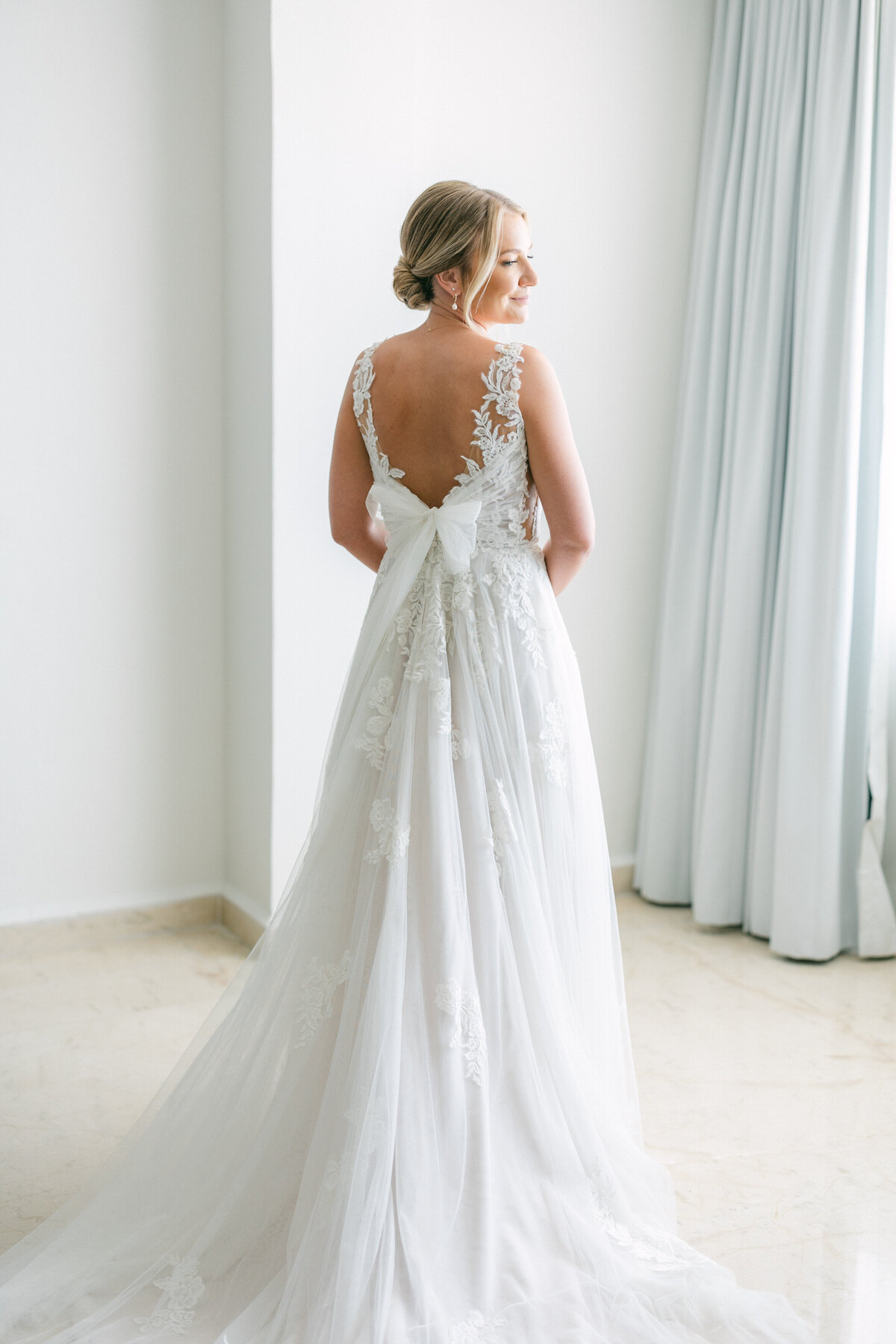 Back view of bride’s lace gown with bow detail, ready for her Cancun wedding, photographed by a Philadelphia-based pro.