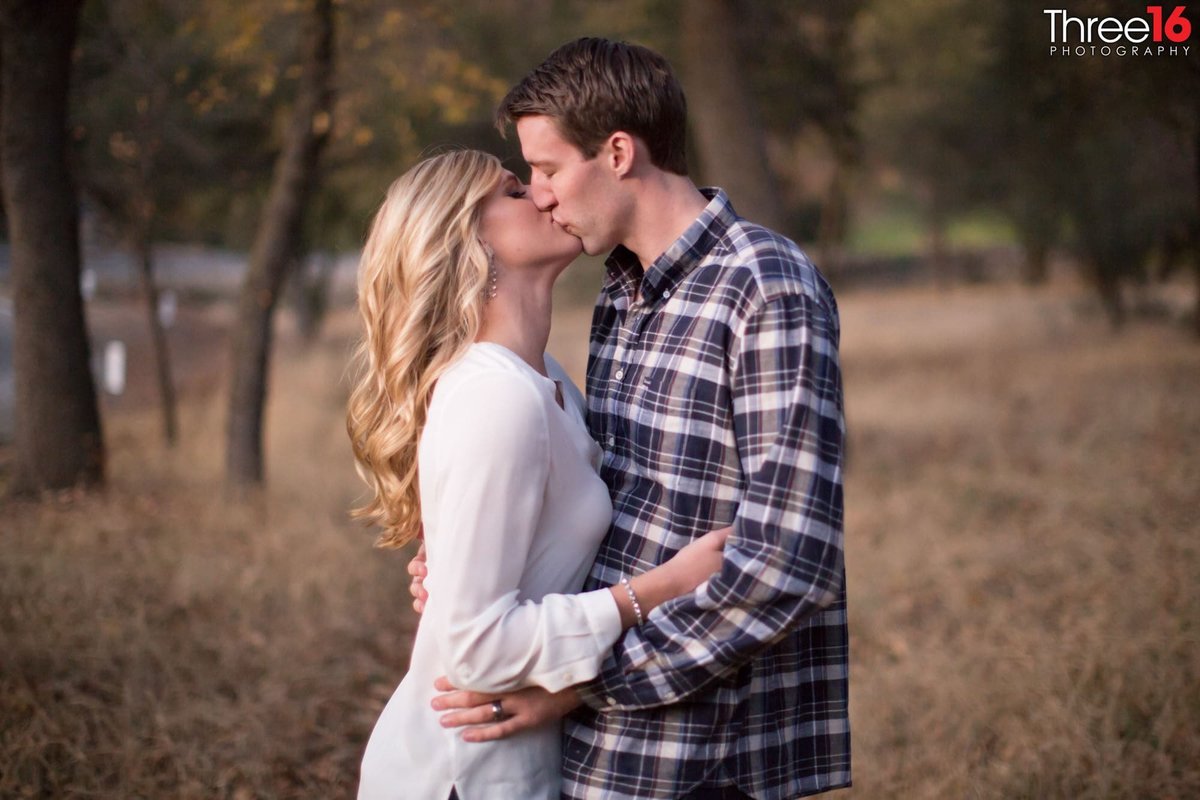 Engaged couple share a kiss during photo shoot
