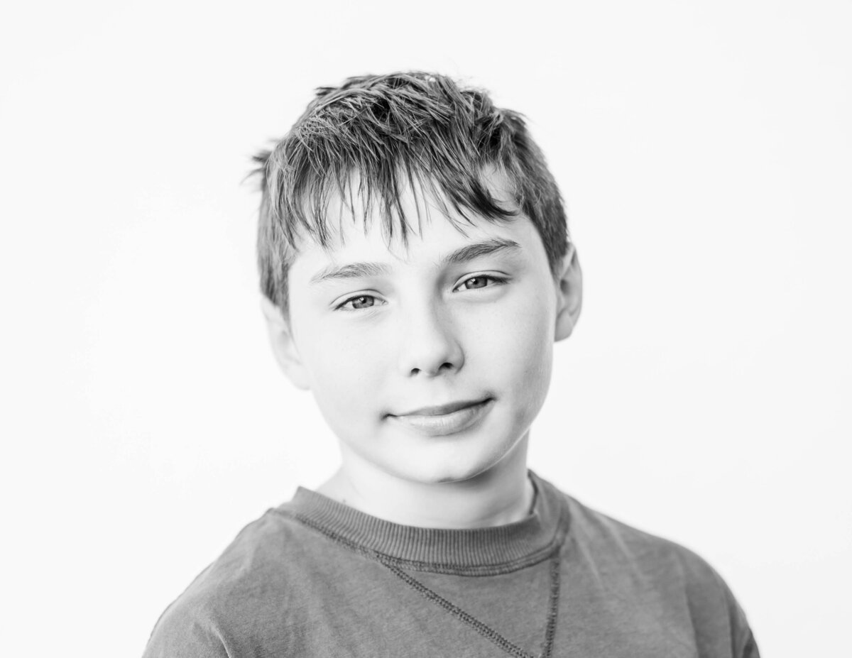 Fine art photo of 8th-grade boy in casual pose, bright backdrop