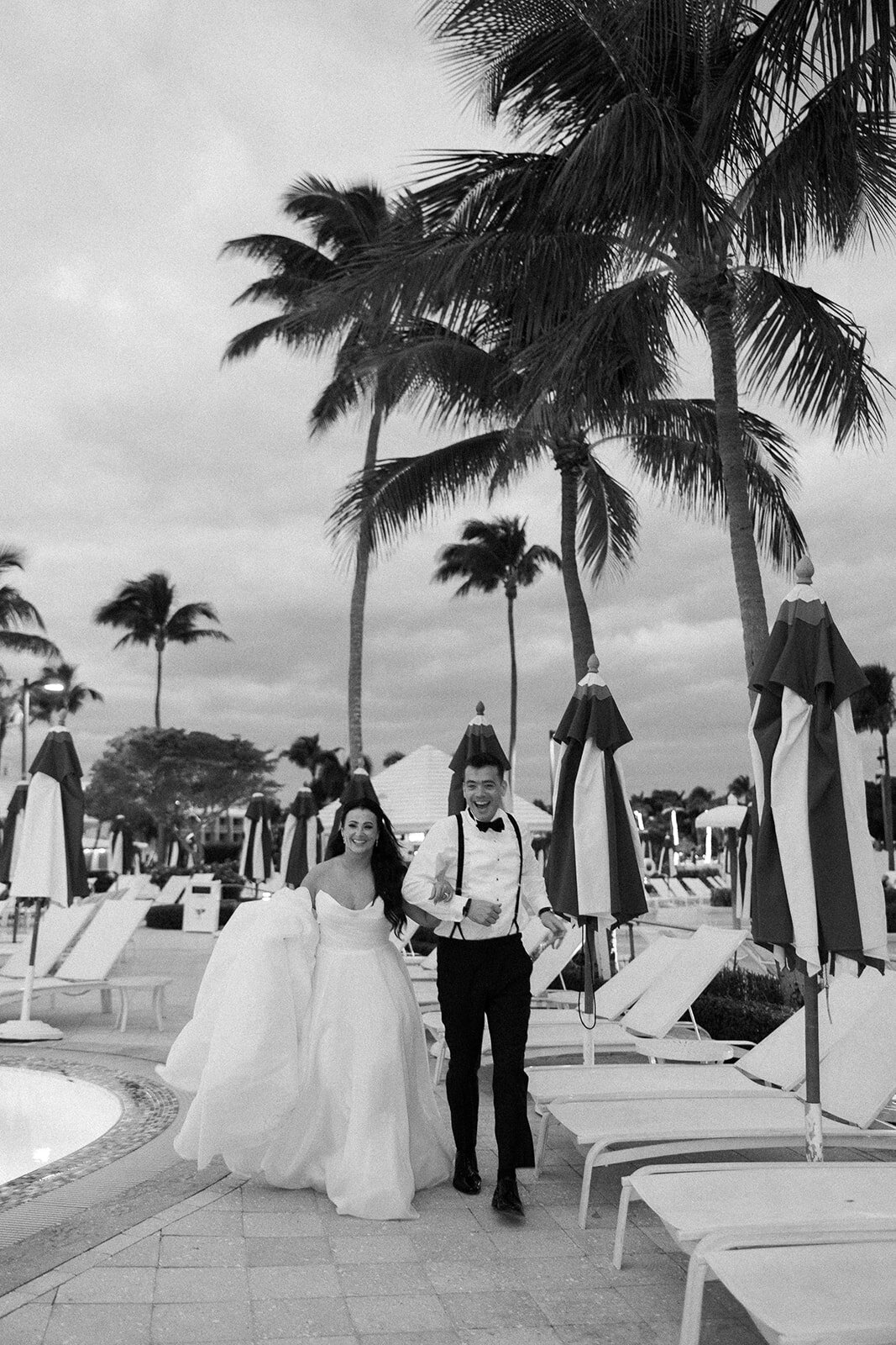 The newlyweds joyfully walk hand-in-hand under the swaying palm trees at Ocean Reef in Key Largo.