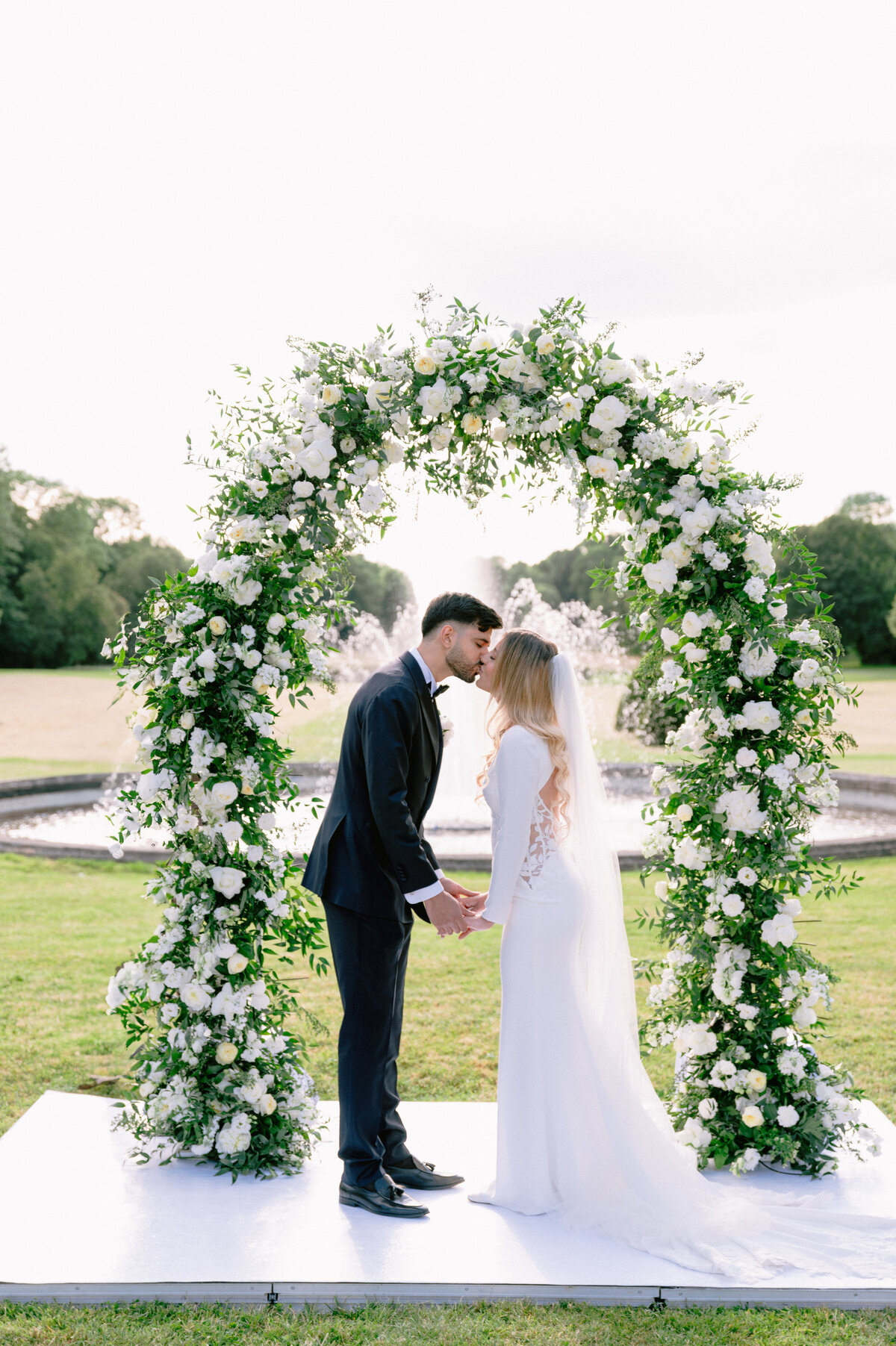 Mariage château de Champlâtreux Paris Photographe ceremonie laique arche florale baisé