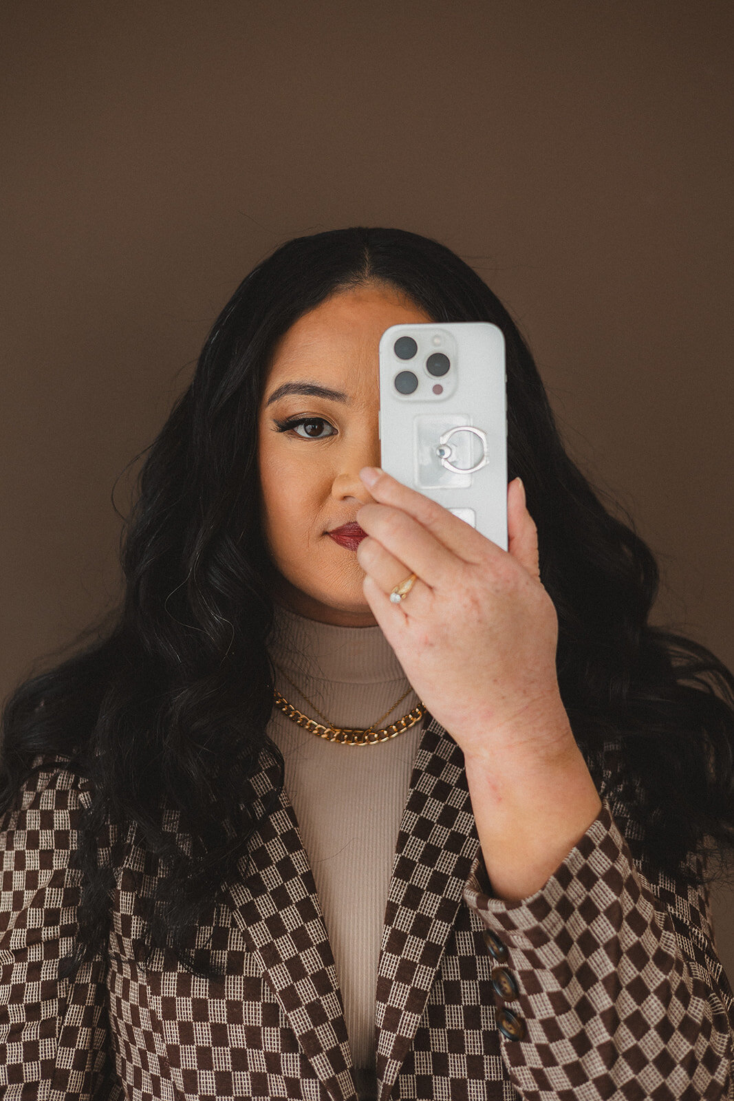 A woman holds a phone up to her eye
