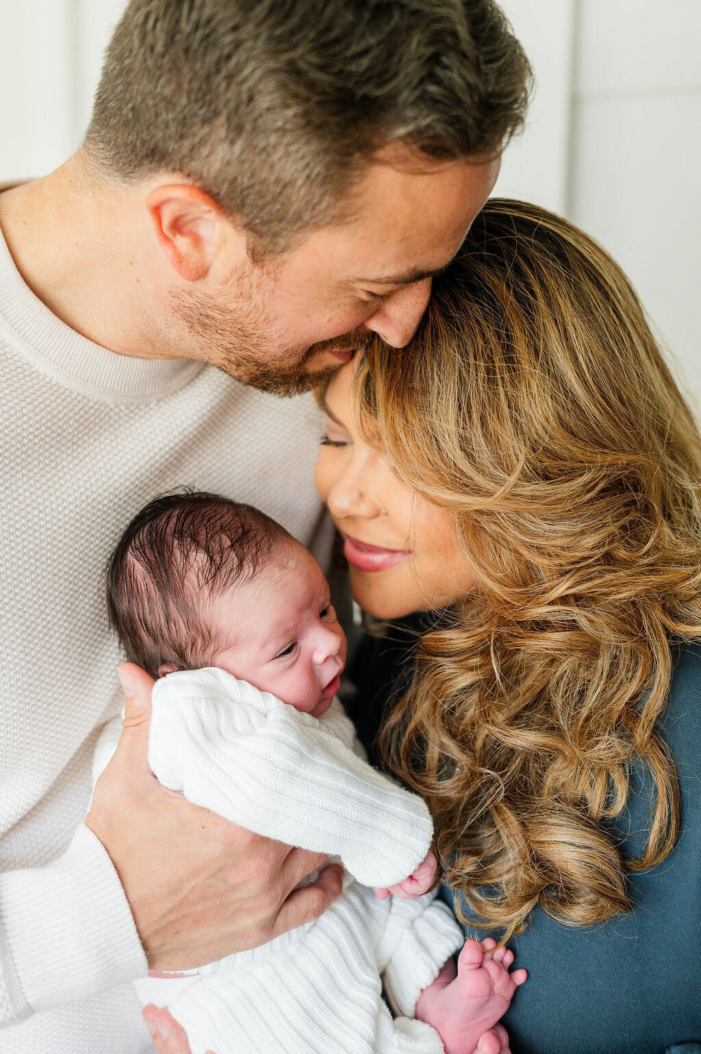 Newborn baby boy with his mom and dad all snuggling in taken in Westwood, MA by the best newborn photographer in Westwood