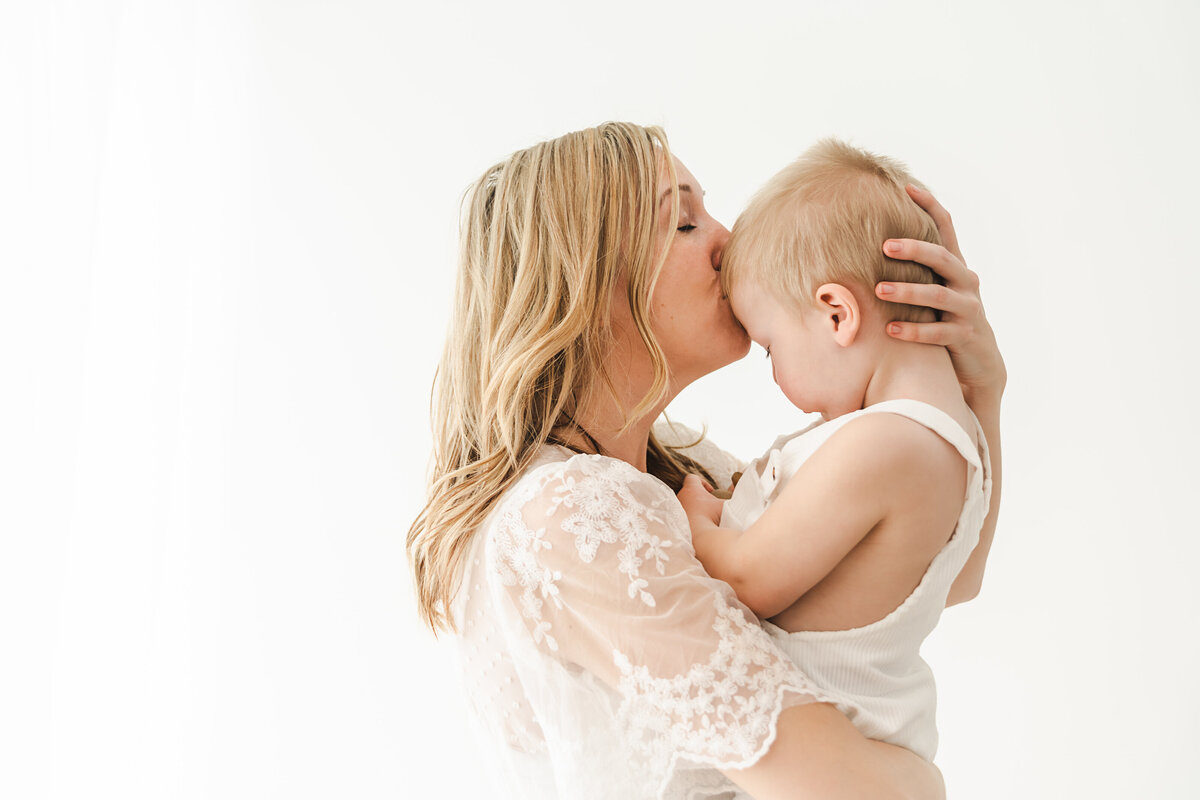 Mom kissing little boy on the head taken by Stickan Photography as an Andover Newborn Photographer