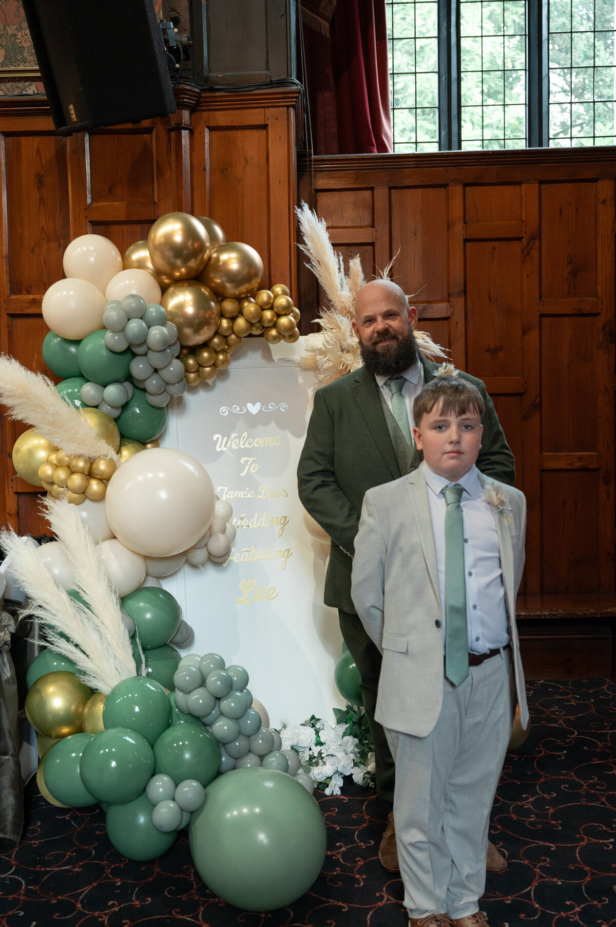 Groom and his son before ceremony next to wedding welcome sign - Worsley Court House Weddings - Manchester Photography