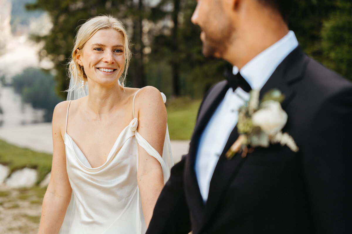Bride smiling at groom during candid lakeside moment