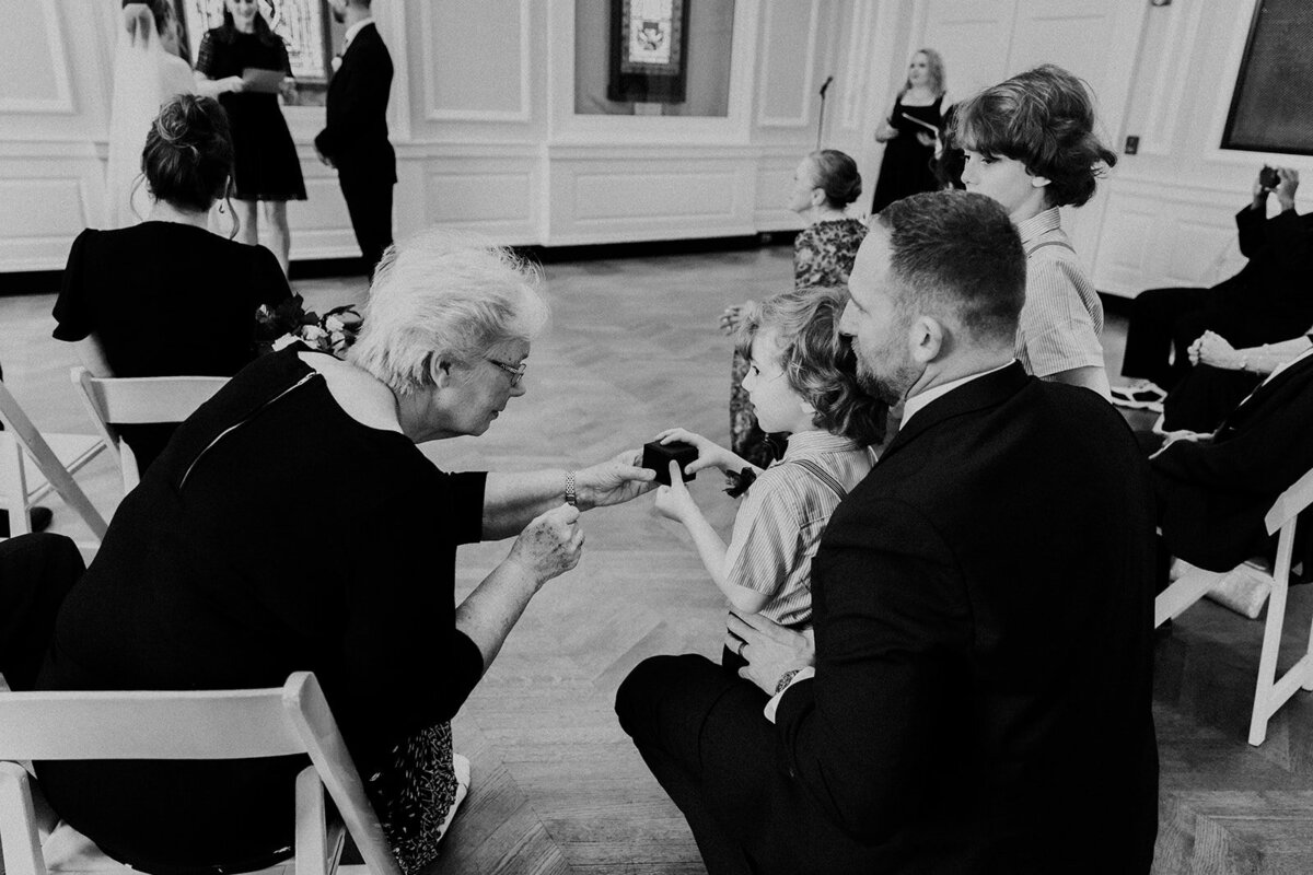A guest passes the wedding ring box to the ring bearer during the wedding ring blessing.