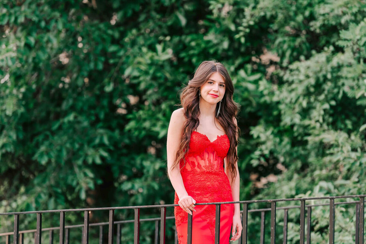 A waist up close up of the grad in a red dress. 