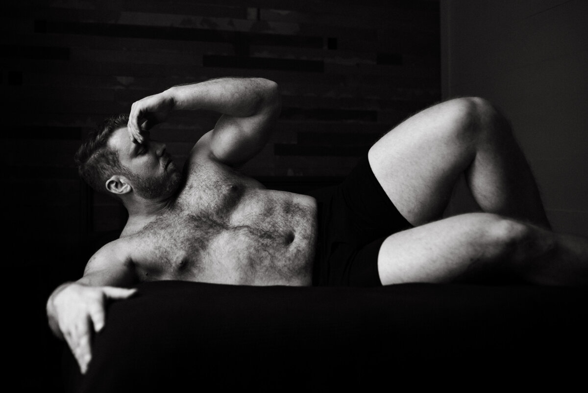 male boudoir pose on bed