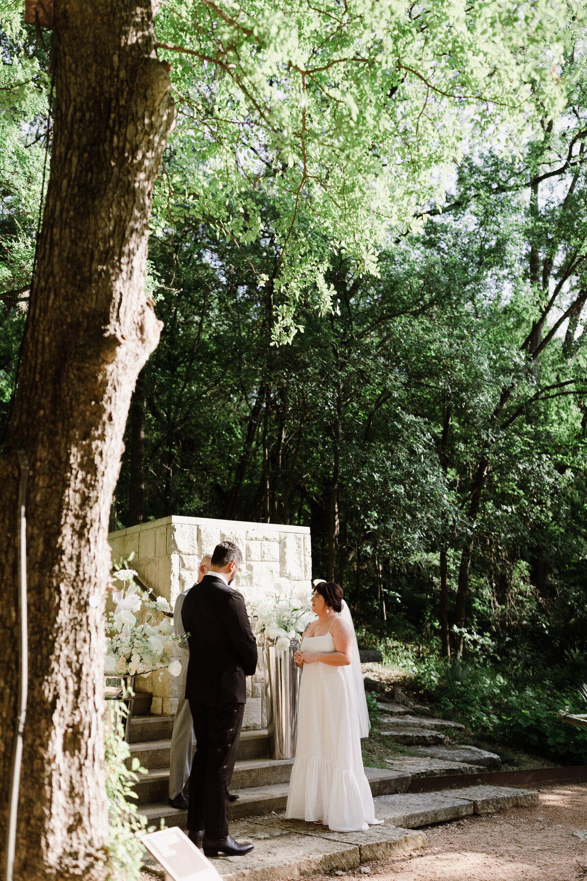 Bride and groom at outdoor wedding ceremony at Umlauf Sculpture Garden, Austin