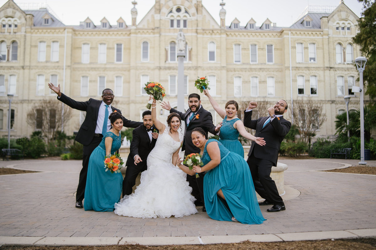 wedding party posing in front of St. Mary's University sign in San Antonio