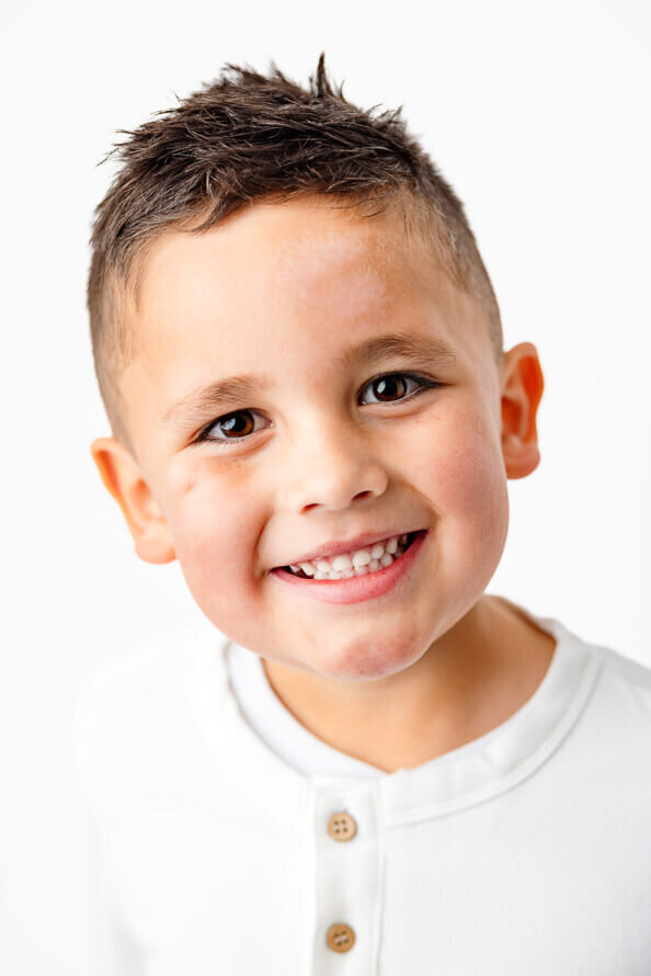 Close up of cute kid on white backdrop.