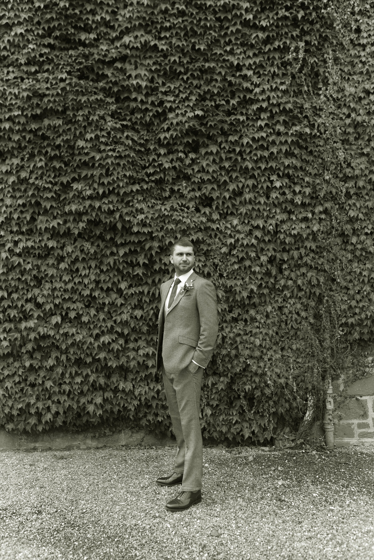 Blakc and white wedding photograph of Groom in Squires Outfitters tweed wedding suit in the grounds of Cromlix House for his summer wedding in 2024.