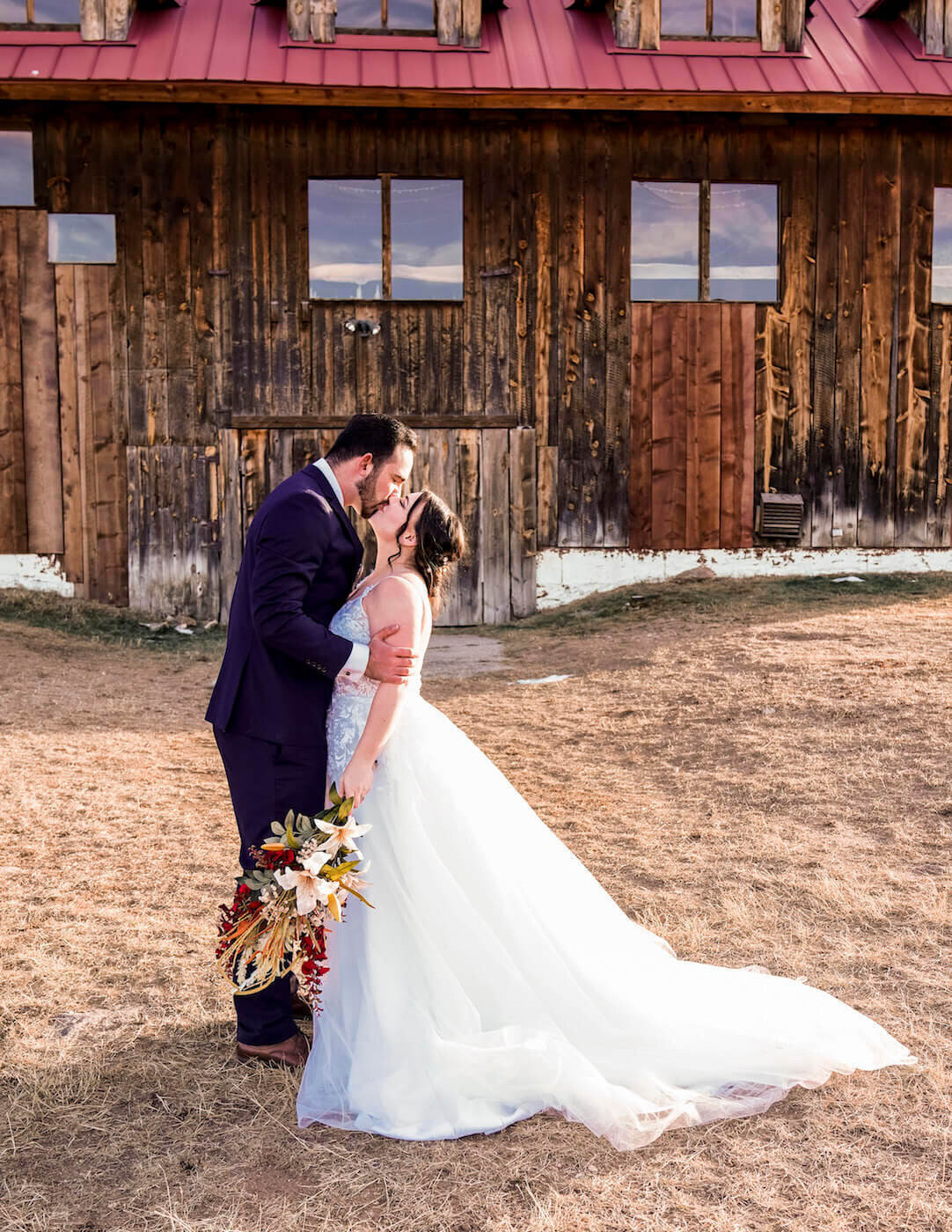 wedding_photography_denver_colorado_-_couple_kissing_in_front_of_barn
