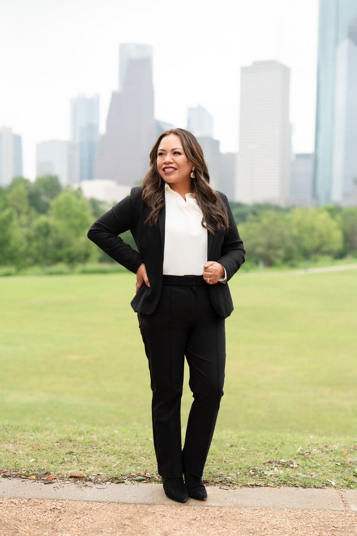 Marilly Mendez standing confidently outdoors with Houston skyline behind