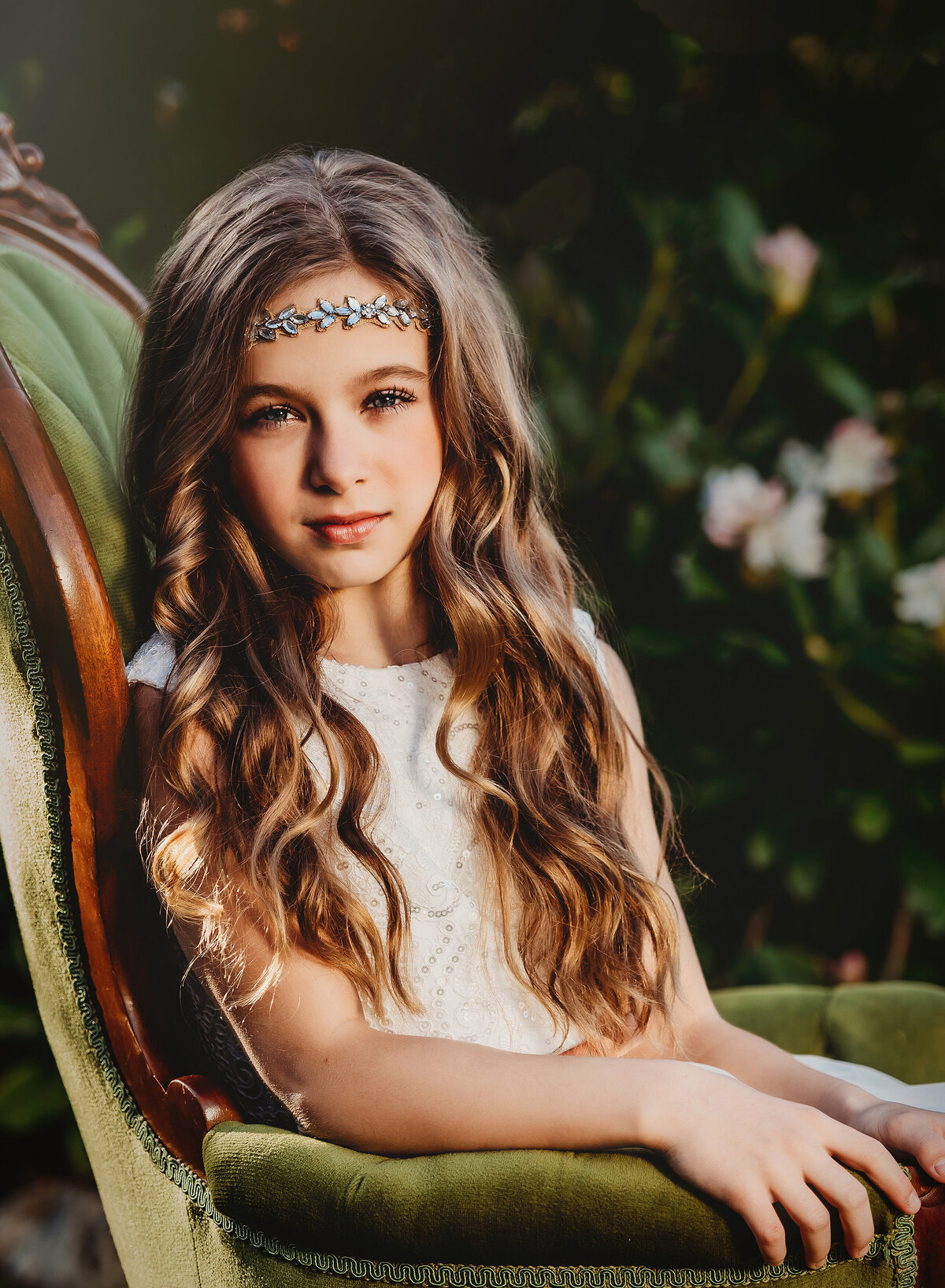 Photo of girl in green velvet victorian chair with long hair in white dress