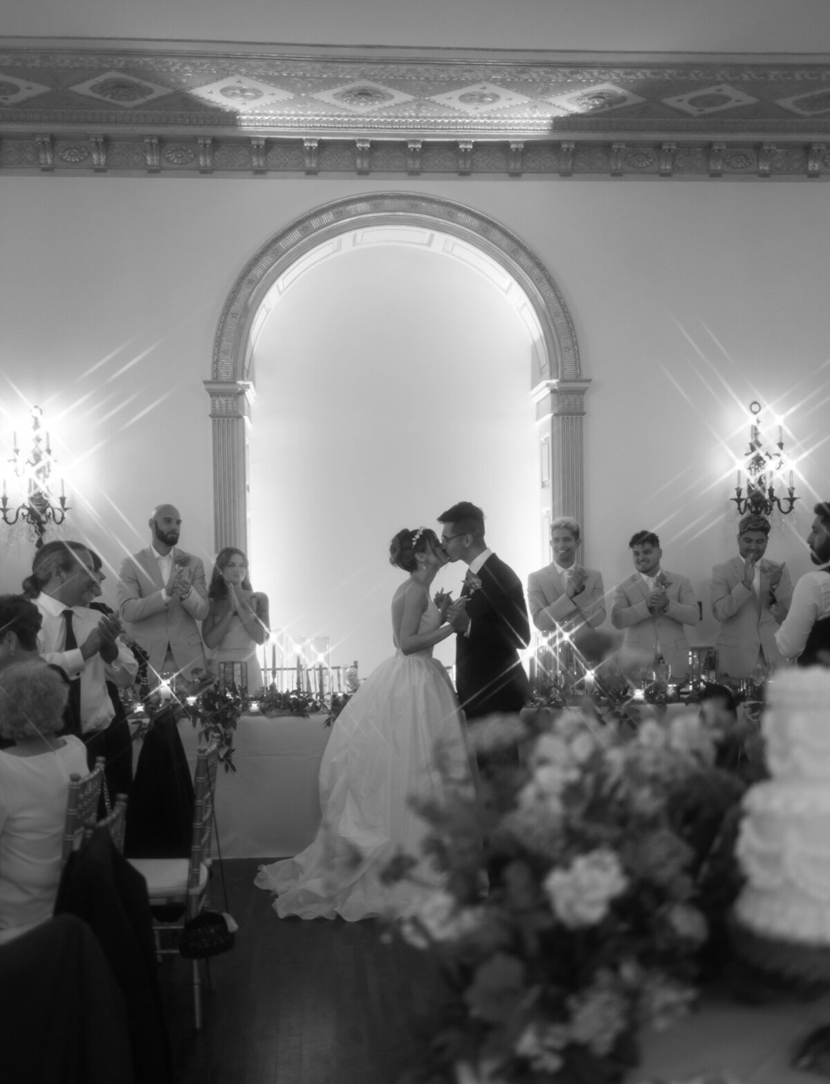 A bride & groom kiss under ornate architecture detail at The Colony Club, unique Detroit wedding venue