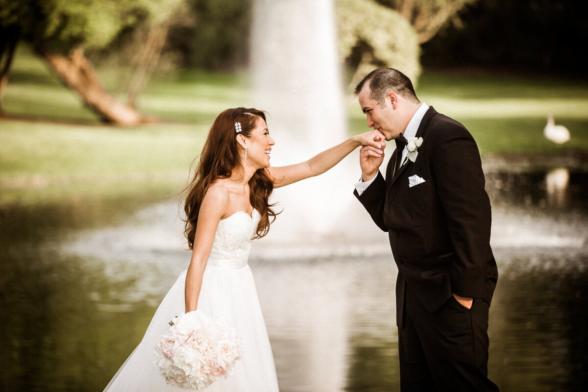 A groom kisses the brides hand before their wedding at the Concorde Banquets in Kildeer, IL