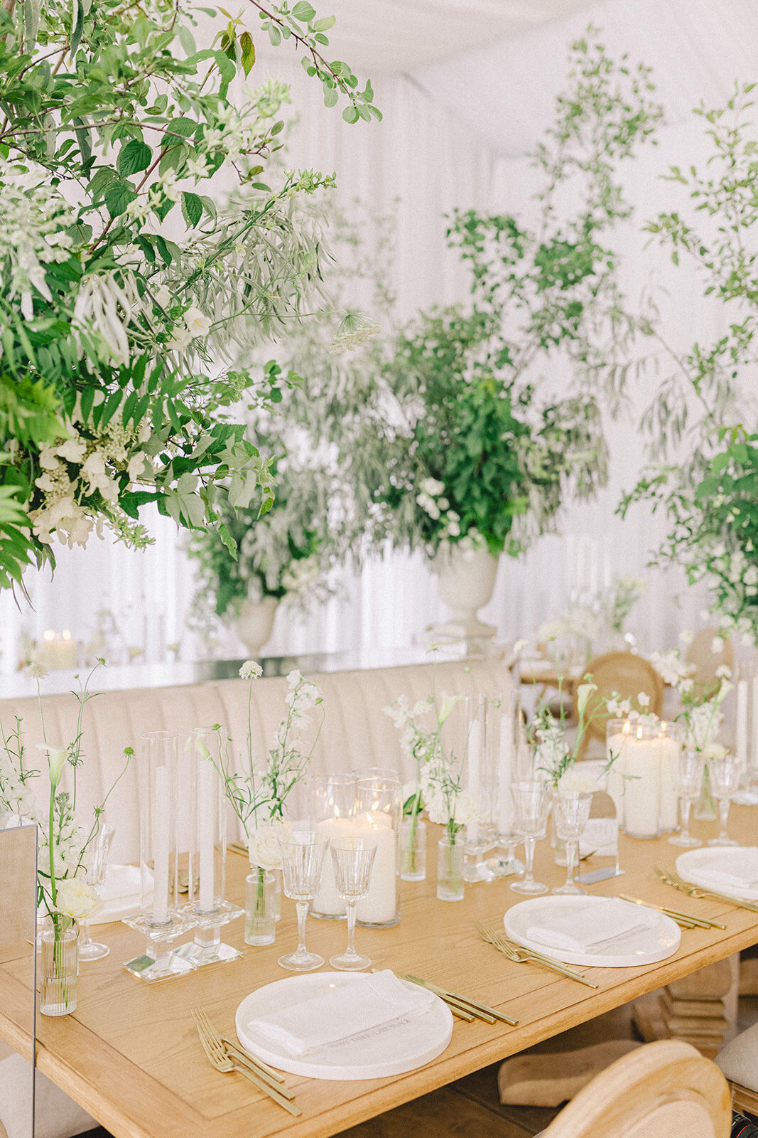 Bud vases of white flowers and large urns of elegant greenery form an elegant centrepiece display at the Willow Inn.