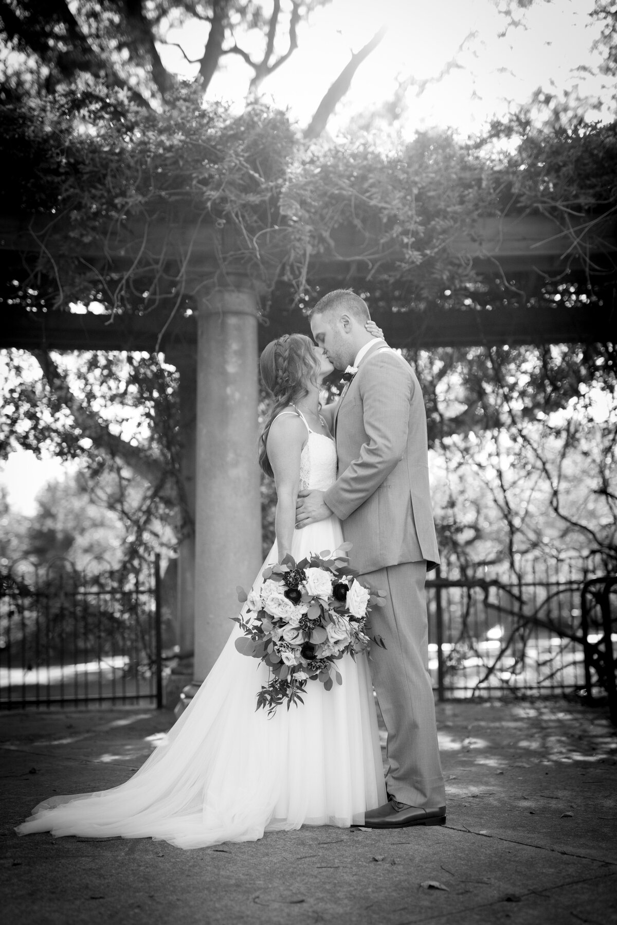 couple kissing under arch