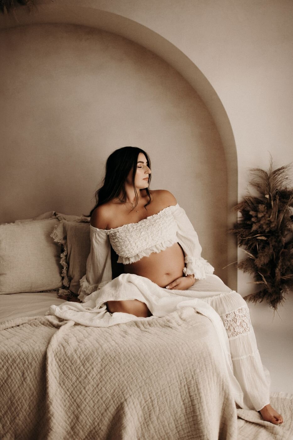 Peaceful pregnant woman in a white lace top and skirt during a maternity photoshoot in Mullingar