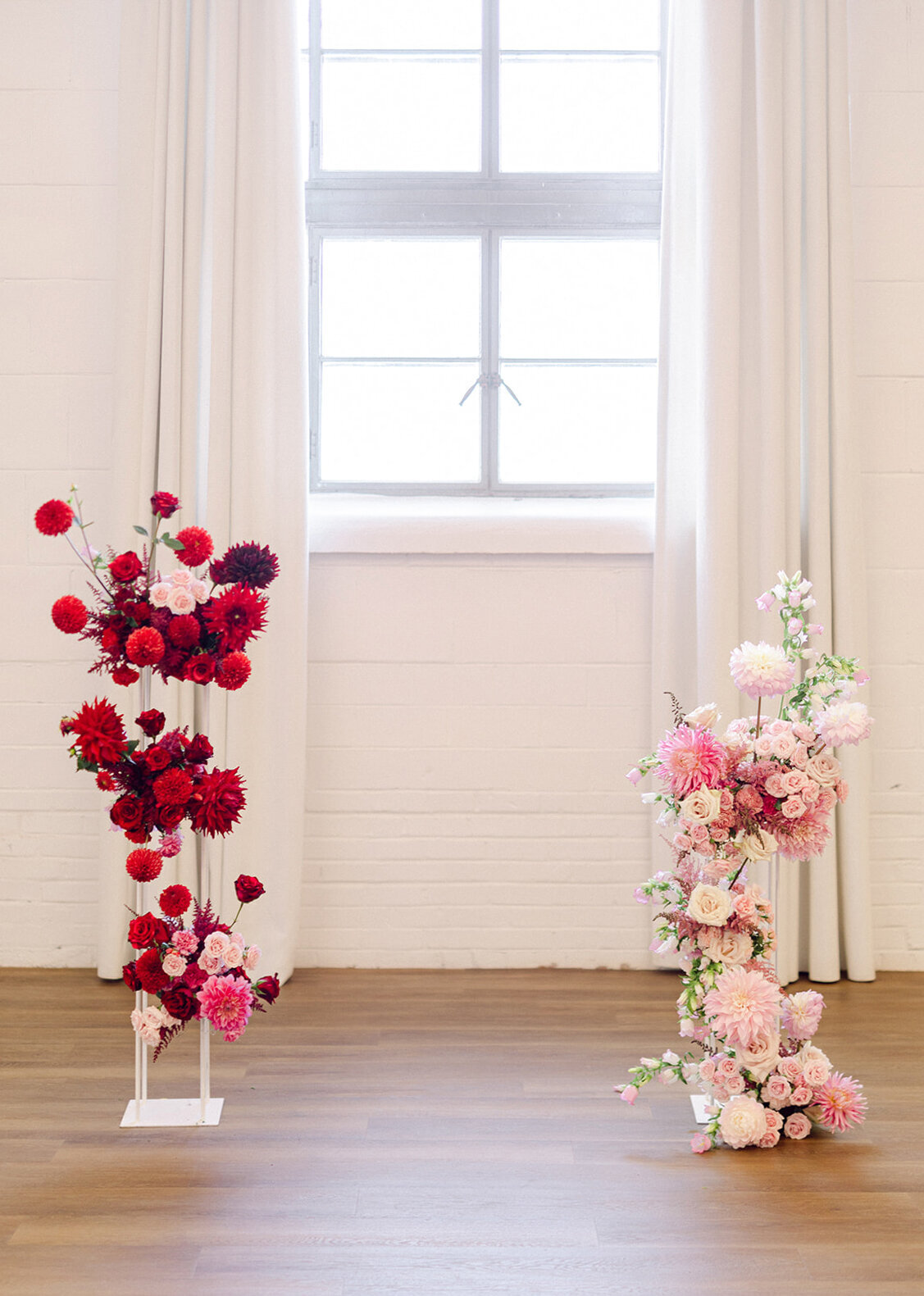 Two bright, modern flower arrangements, red and pink, decorate The Rye for a wedding ceremony.