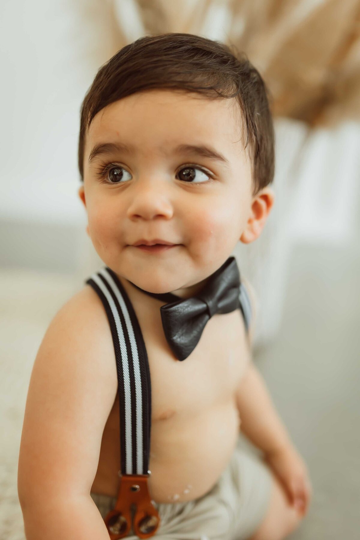 baby boy wearing a black bowtie and suspenders