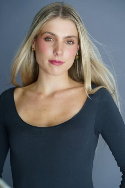 Modeling headshot of a woman with long hair wearing a tight fitting top with long sleeves