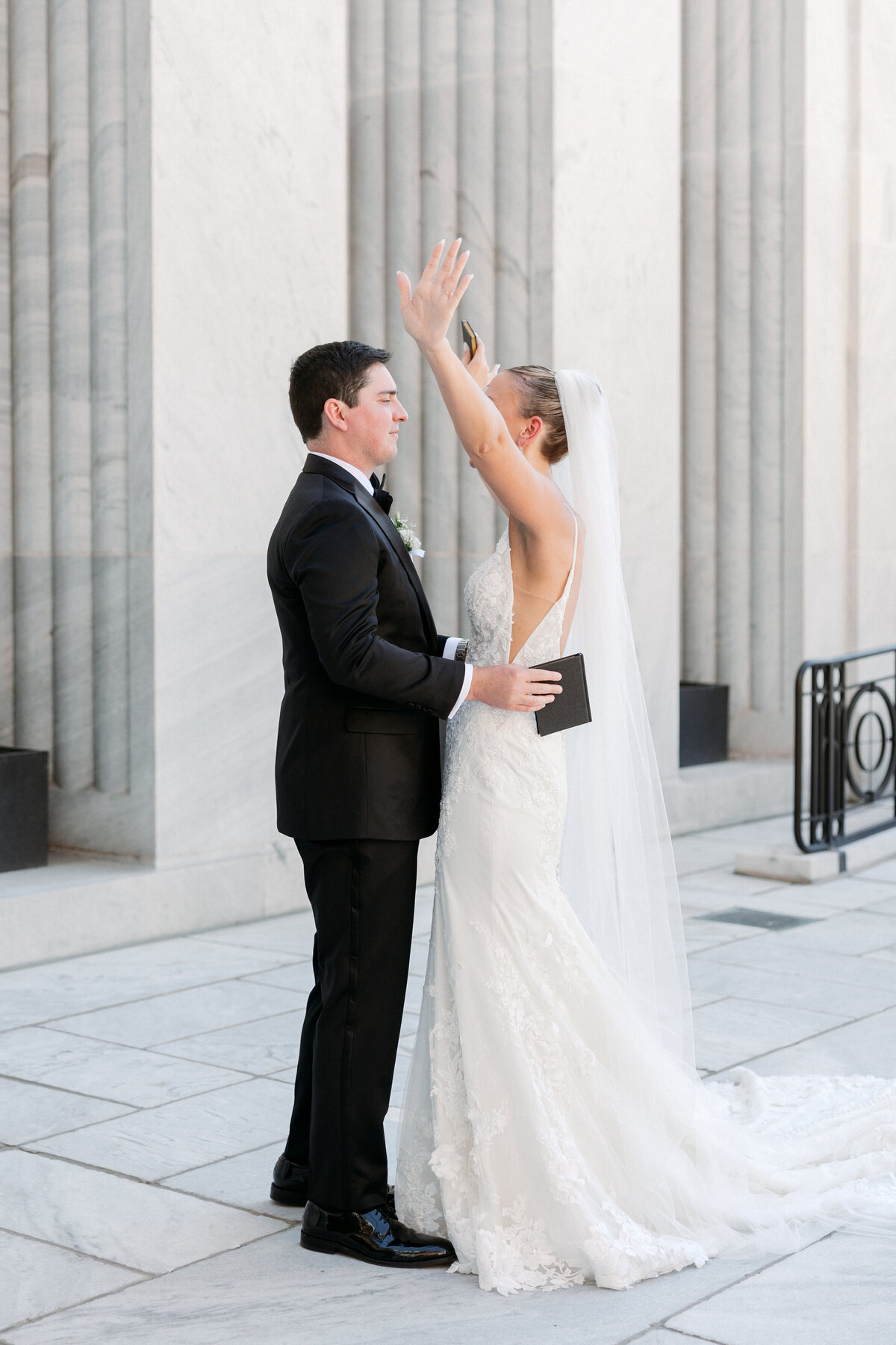 Bride raises hands joyfully after exchanging vows outdoors, photographed by a Philadelphia wedding photographer.
