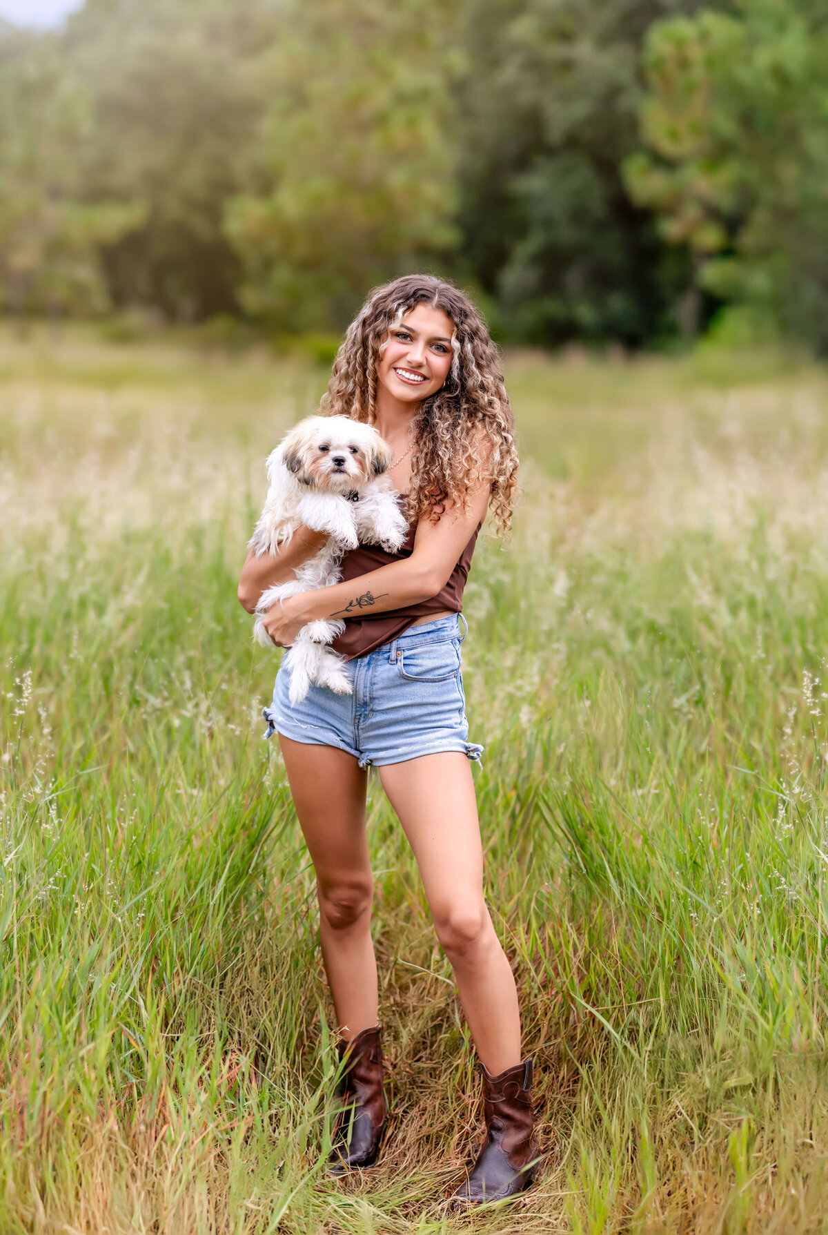 Windermere senior session featuring a teen girl holding her fluffy dog in the grass.