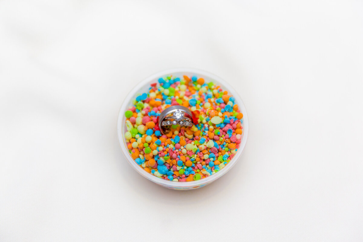 A colorful bowl of candy with rings in the middle.
